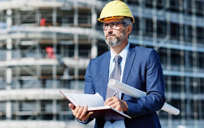 Professionnel du bâtiment remettant une attestation d'assurance décennale à son client avant le démarrage du chantier