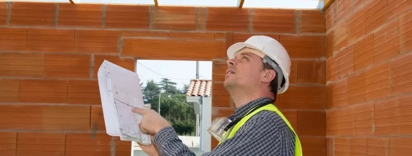 Expert technique en bâtiment effectuant une expertise de sinistre décennal sur chantier